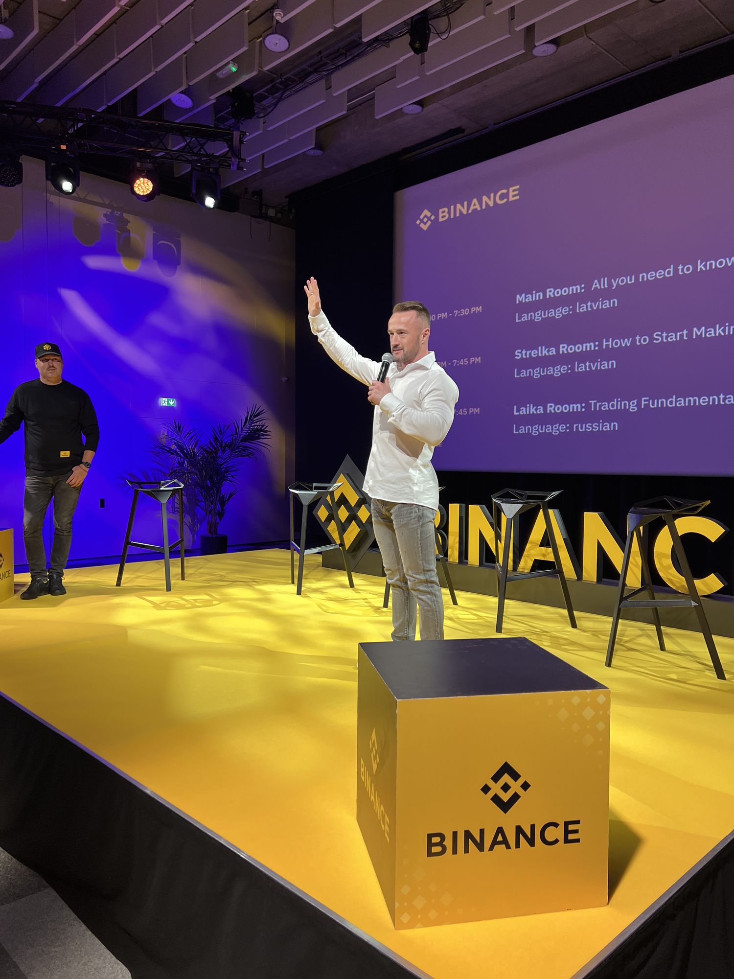 Виталий Филимонов с микрофоном на сцене мероприятия Binance